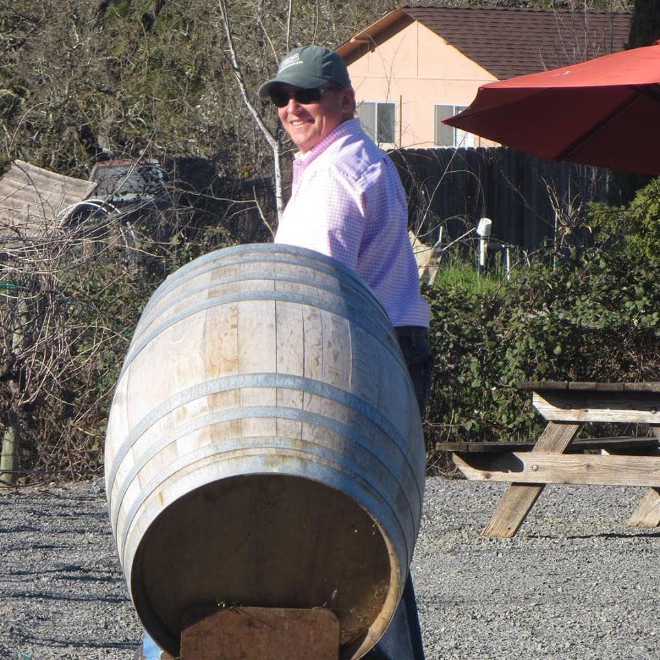 Getting ready for Barrel Tasting by rolling out empty barrels to use as cocktail tables in our vineyard patio